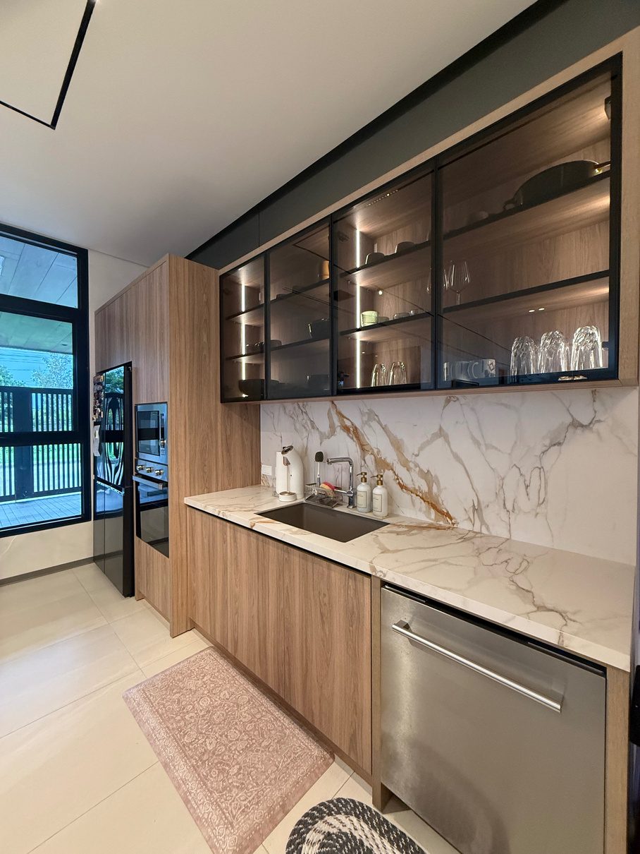 Kitchen with glass display cabinets, marble worktop, and integrated lighting