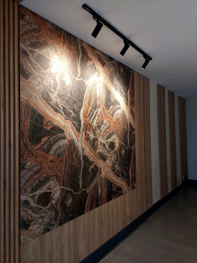 Marble feature panel framed by timber slats and track lighting