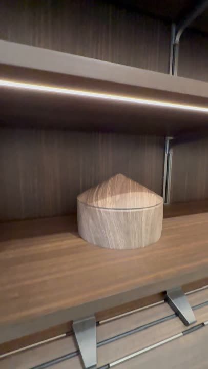 Timber shelf with concealed lighting and a ceramic object